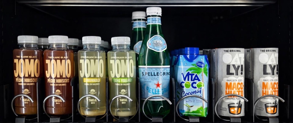 Canettes de boissons bio alignées dans un distributeur KM Vending